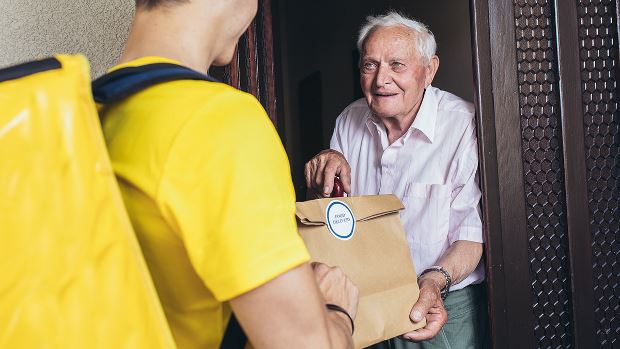 Elderly man on Medicaid accepts a food delivery.
