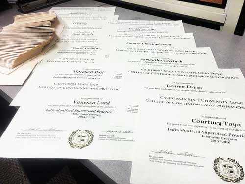 An image of certificates laid down on a desk