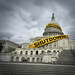Capitol building with yellow tape around it. Tape reads "shutdown."