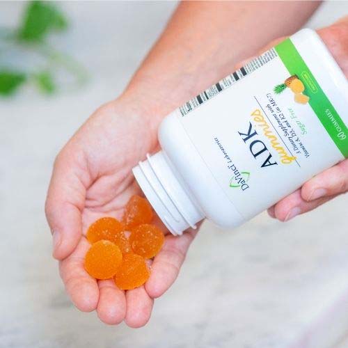 ADK Gummies | Gummies pouring out of a jar tipped over so the gummies land in an open hand