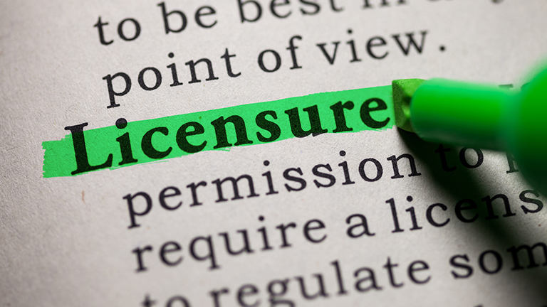 marker highlighting the word "licesnure" in a book