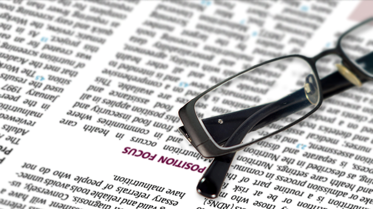 pair of glases laying on a position paper in the journal