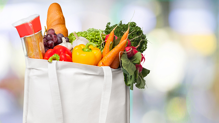 A bag of groceries including essentials such as pasta, vegetables and bread, sit on a counter and show the importance of the Supplemental Nutrition Assistance Program, also known as SNAP.