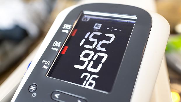 A blood pressure monitor showing high diastolic and systolic numbers, representing possible hypertension/high blood pressure.