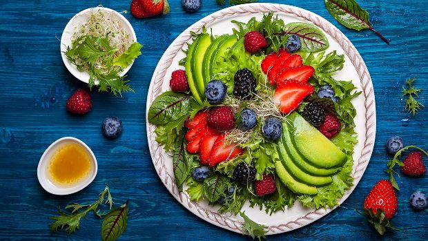 Plate of salad greens with berries, which are part of the MIND diet.