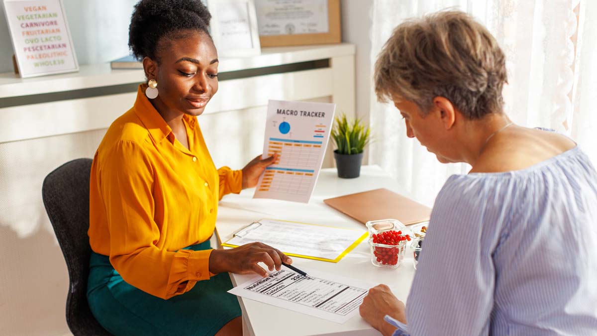 A Seat at Every Table | Registered Dietitian in Yellow Shirt Talking to Client