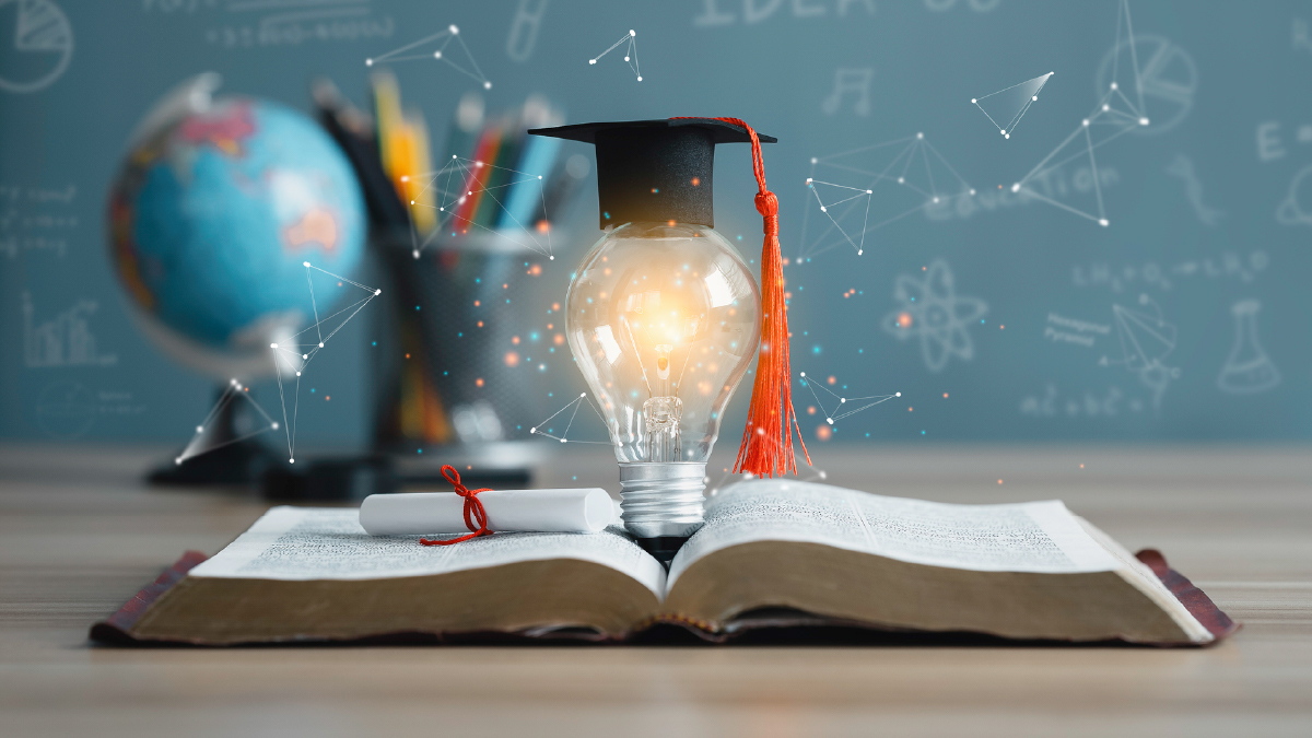Book open on desk with lightbulb emerging from its pages