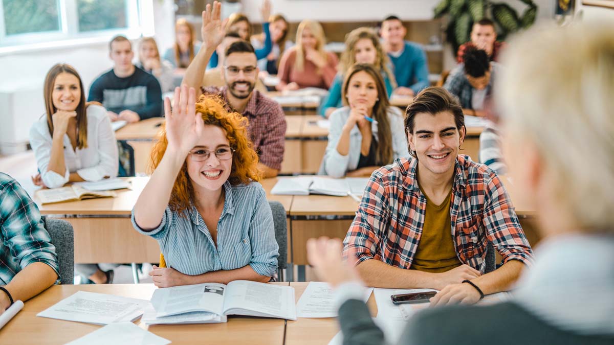 Students raising hands in classroom